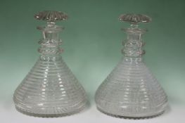 A pair of cut glass ships decanters with segmented mushroom stoppers. 24cm high. 17cm diameter.