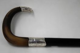 A gentleman’s ebony walking stick with rhinoceros horn handle and silver coloured mounts. 80cm long.