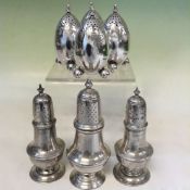 A set of four silver pepperettes of ovoid shape on three ball feet. Edinburgh 1874 together with a