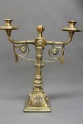 A pair of late 19th Century Arts and Crafts brass five branch candelabra with scroll and leaf