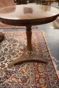 A carved mahogany William IV circular wine table. Fluted tapering pedestal. Triform platform base on