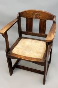 An Arts and Crafts oak armchair. In the manner of Punnet. With carved stylized leaves to back. Plain