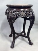 A Chinese carved hardwood jardiniere stand with inset marble top. 38cm diameter. 62cm high.