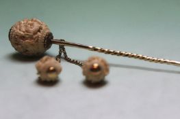 A 19th century oriental carved ivory and white metal hat pin with chain attached tassles.