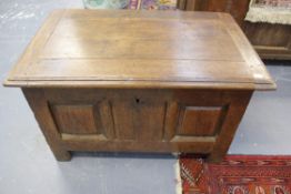 An early oak coffer of diminutive size. Moulded edge top over. Recessed panel front on stile feet.