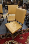 A set of antique carolean style oak and leather upholstered dining chairs to include two armchairs.