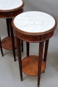 A pair of French Louis XVI style inlaid gueridons with inset circular marble tops. Tapered fluted