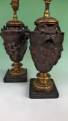 A pair of French bronze and brass table lamps with rams mask handles. The main bodies with cavorting