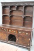 An 18th Century and later oak dresser and plate rack, with three drawers over two cupboards flanking