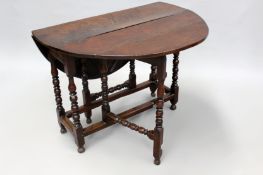 An 18th Century carved oak gate-leg table of good colour with apron drawer and ring turned,