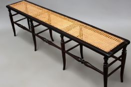 A Victorian cane seat window bench with turned legs and stretchers. 152cm long.
