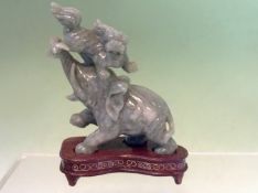 A Chinese jade model of an elephant and shi shi with plinth. 10cm high. (boxed).