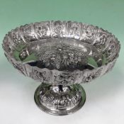 A late 19th Century silver comport with repousse fruit and foliate deigns to centre and rim.