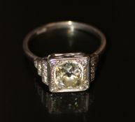 A platinum set single cushion shaped diamond ring with stepped diamond shoulder. Centre stone