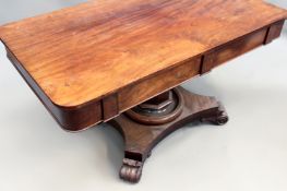 An early Victorian carved mahogany library table. Four apron drawers. Tapered pedestal on shaped