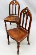 A pair of Victorian carved oak Gothic Revival hall chairs. Crests with pierced trefoil designs.