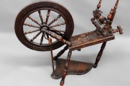 An 18th/19th Century beech and oak cottage spinning wheel.