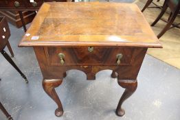 An antique walnut lowboy fitted with single drawer above an arched frieze. Cabriole legs on pad