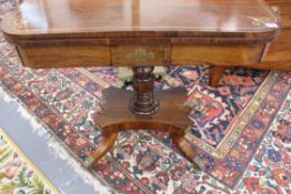 A Regency rosewood fold over card table. Brass strung and inlaid decoration. On turned column over