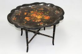 An early 19th Century papier mache paint decorated tray on stand. 76cm wide. signed clay