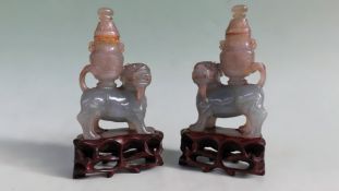 A pair of Chinese green jadeite models of temple dogs with urns on their backs. Plinth bases. 9cm