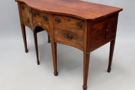 A Georgian inlaid mahogany serpentine sideboard. Central shallow drawer flanked by deep drawers.