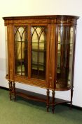 An Edwardian rosewood and boxwood inlaid display cabinet. Bow sided glass panels flanking a pair