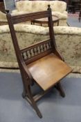 A late Victorian oak, arts and crafts style folding seat clerks stool