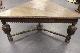 A Victorian unusual carved oak triangular form centre table. In the Jacobean style. Baluster legs