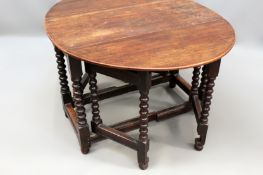 An 18th Century and later oak double gate-leg table with bobbin turned legs united by stretchers.