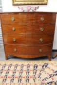 A late Regency mahogany bowfront chest. Two short drawers over three long graduated drawers.