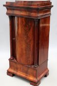 A 19th Century mahogany Biedermeier pedestal form cabinet. Shaped stepped top over frieze drawer