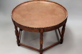 A large polished copper Eastern circular tray with ribbed rim. Conforming oak base with