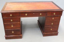 A mahogany pedestal desk fitted with three frieze drawers and three short graduated drawers to