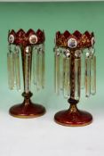 A pair of 19th Century Bohemian ruby glass table lustres hand painted with panels of flowers. 31cm