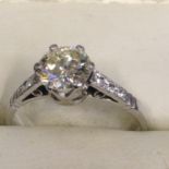 A single stone brilliant cut diamond ring with diamond set shoulders. Centre stone approximately one
