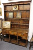 An Georgian oak dresser and rack. Boarded back with three shelves over arrangement of five drawers