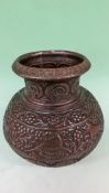 An Eastern relief decorated baluster form copper vase. Bands of scrolling foliage with stylized