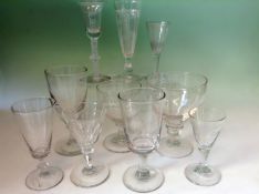 Nine assorted drinking glasses. One with a white spiral stem.