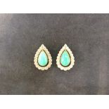 A pair of diamond and turquoise tear shaped ear studs with centre turquoise and diamond border.