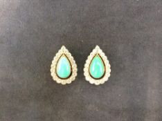 A pair of diamond and turquoise tear shaped ear studs with centre turquoise and diamond border.