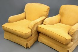 A pair of Howard style deep seat armchairs, ring turned tapered short legs end in brass castors.