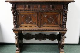 An antique carved walnut Italian Baroque style cabinet. Two drawers above two panelled cupboard