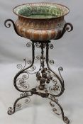 An antique wrought iron Baroque style jardiniere stand. With copper lobed form bowl. Scroll work