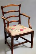 A George III mahogany ladder back armchair with broad drop in seat pad shaped arms. On square