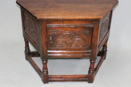 A 17th Century style oak credence type cabinet with carved panelled door, turned legs, plain