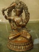 Tibetan patinated and silvered bronze figure of a seated deity. 22cm high.