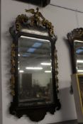 A George III parcel gilt carved fretwork mirror with gilded phoenix finial. 120cm high x 56cm wide.