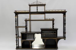 An Aesthetic Movement ebonized wall shelf with pierced brass galleries. Bevelled glass cabinets,