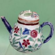 A Chinese export famille rose teapot and cover. Raised floral decoration. 11cm high.